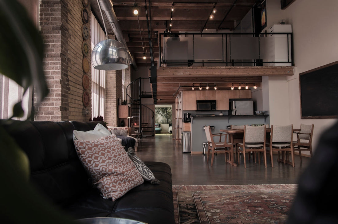 Modern loft apartment with exposed brick, industrial lighting, open kitchen, and cozy living area